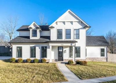 White two-story suburban house with a covered front entry and dark front door, address 3524, neatly trimmed shrubs and a curved walkway leading to the sidewalk.