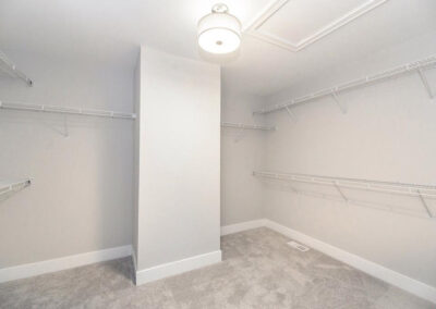 Bright walk-in closet with white wire shelves on three walls and a central support column.
